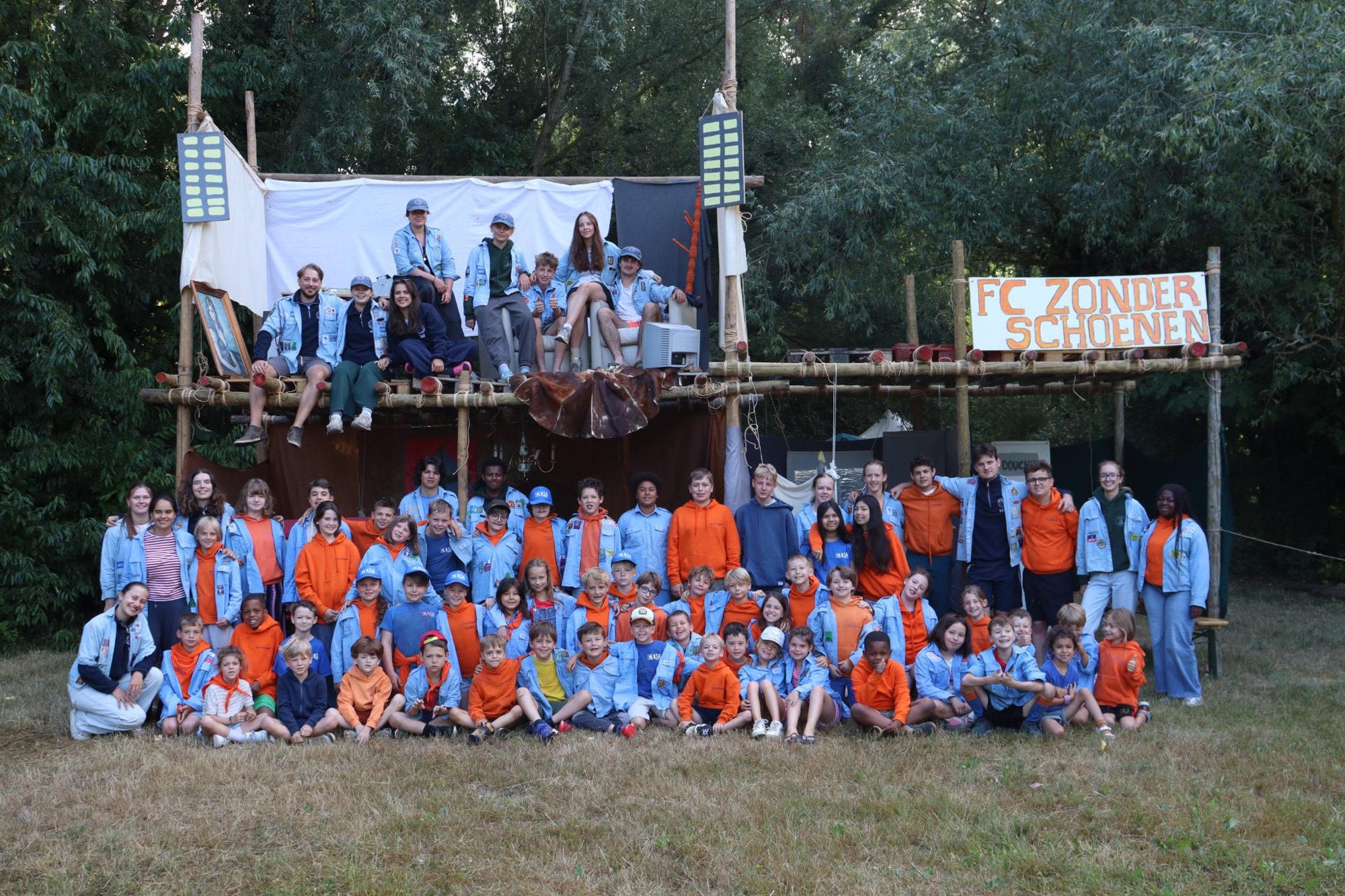 De volledige groep van KSA Waregem op kamp, voor een zelfgebouwde constructie.